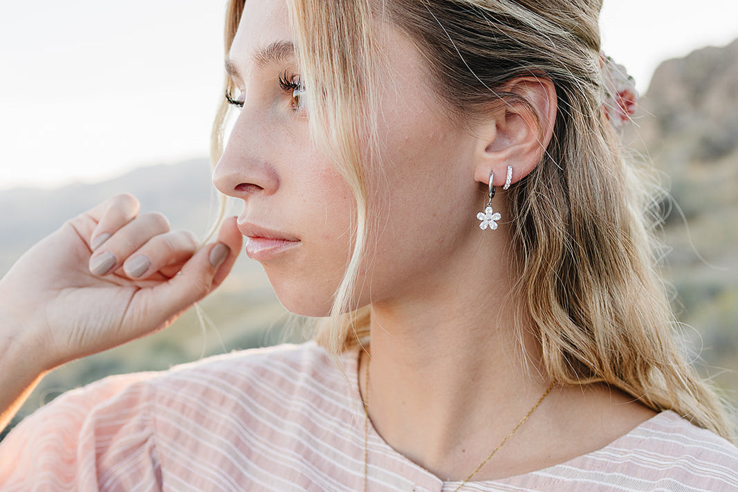 Model wearing the Desert Sol Ember Butterfly Necklace in Opal White with Dainty Hoop Earrings in silver and a Sundust Pave Huggie