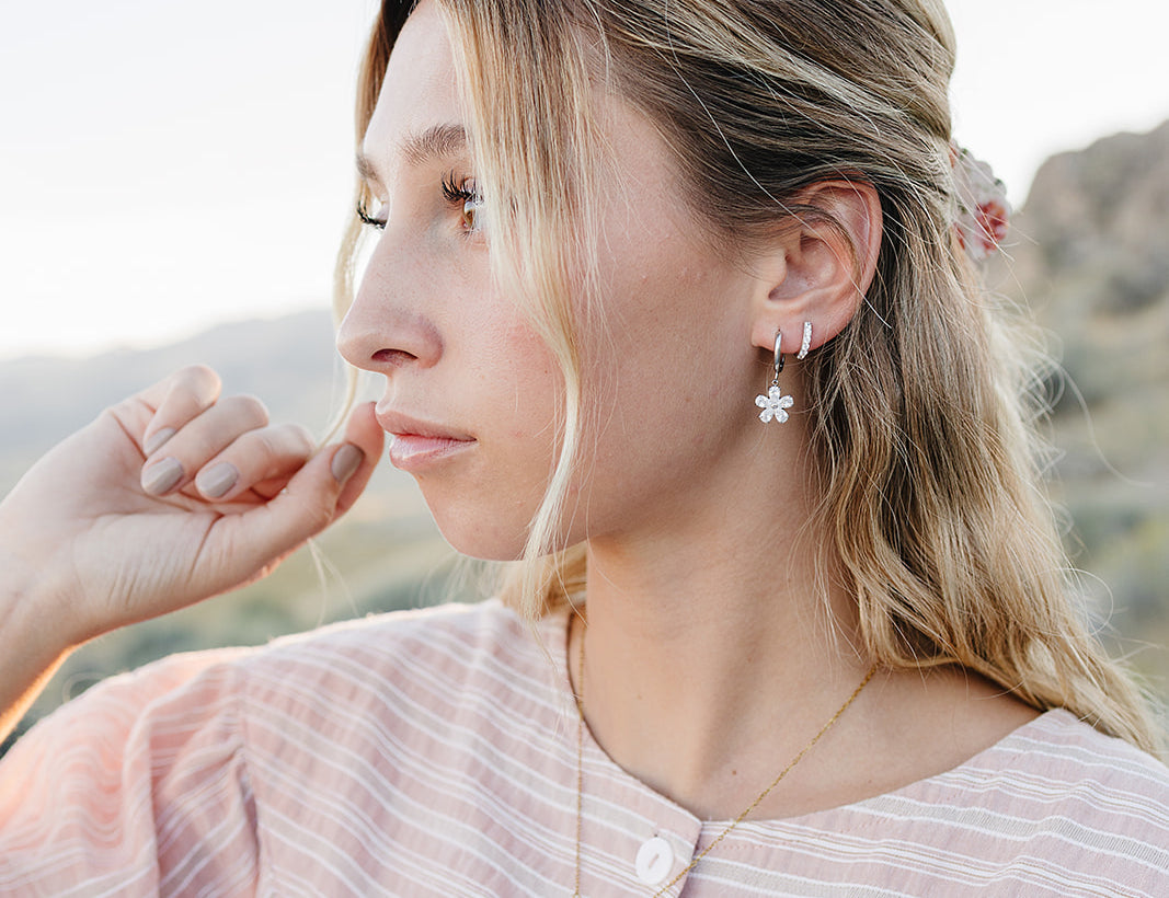 Model wearing the Desert Sol Ember Butterfly Necklace in Opal White with Dainty Hoop Earrings in silver and a Sundust Pave Huggie