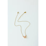 Desert Sol Ember Butterfly Necklace in peach, a faceted crystal butterfly pendant on a warm gold chain, on a white background