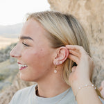 Model wearing the Desert Sol Everflight Butterfly Necklace in Petal Pink with Petal Hoop Earrings and Petal Studs