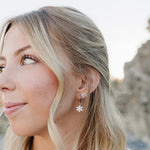Model in profile wearing the Desert Sol Fleur Hoop Earrings in silver