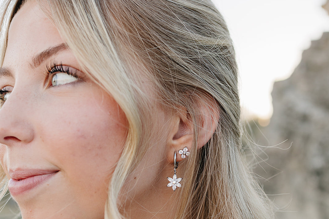 Model in profile wearing the Desert Sol Fleur Hoop Earrings in silver