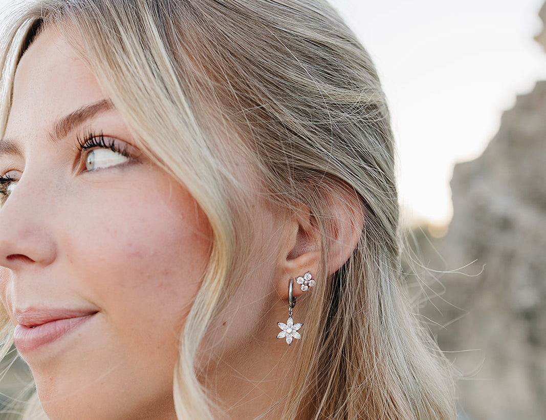 Model in profile wearing the Desert Sol Fleur Hoop Earrings in silver