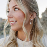 Model smiling in the Desert Sol Fleur Hoop Earrings in silver and a delicate silver necklace