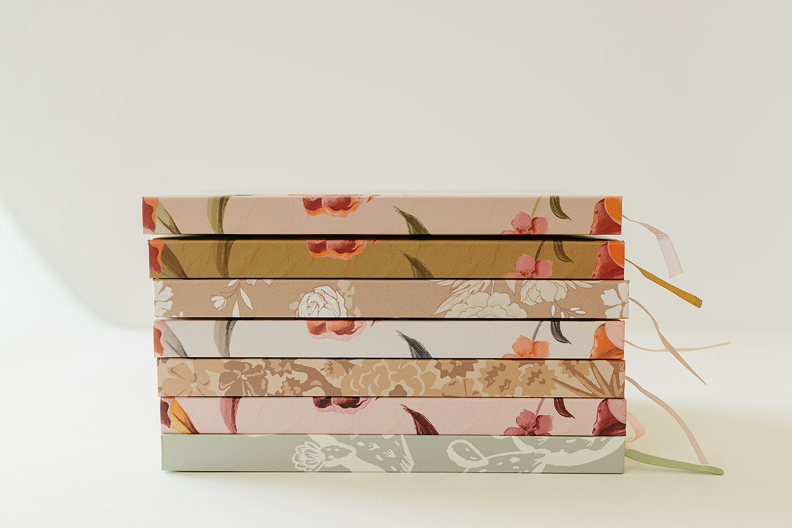 Stack of Desert Sol hardcover notebooks showing the floral spines and ribbon bookmarks