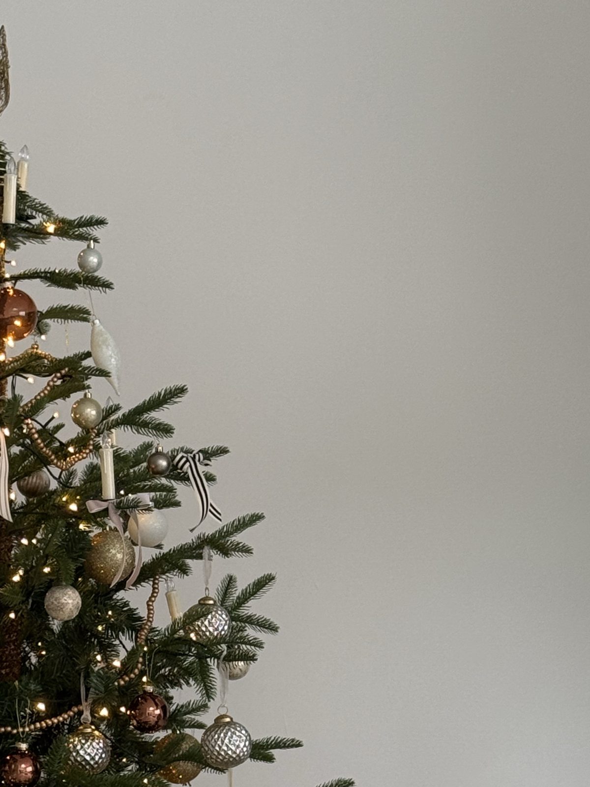 Christmas tree decorated with gold, blush and copper ornaments, ribbon bows and warm white lights for the Desert Sol Holiday Gift Guide