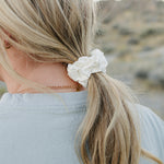 Low ponytail tied with the Desert Sol Mulberry Silk Scrunchie in Ivory