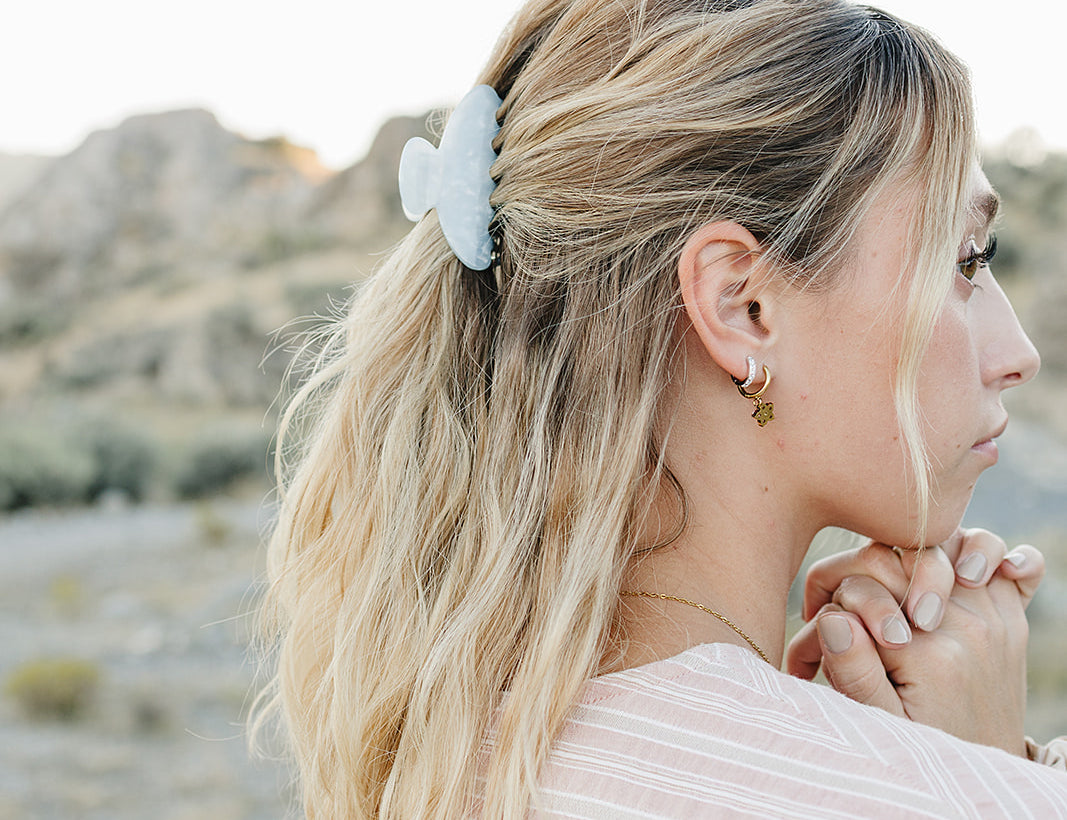 Model with a half up style held by the Desert Sol Classic Claw Clip in Moonstone, desert buttes behind her