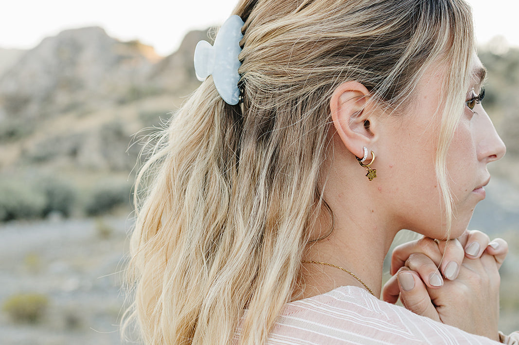 Model with the Desert Sol Petal Claw Clip in Moonstone holding a half up hairstyle