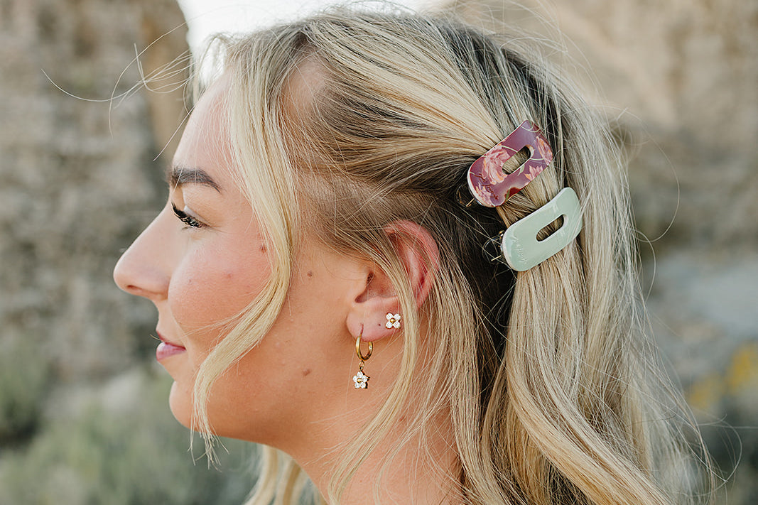 Profile of a model wearing the Desert Sol Oval Lay Flat Acrylic Claw Clip in Soft Sage beside a Mulberry Floral claw clip