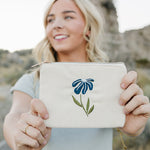 Model smiling and holding the Desert Sol Night Bloom corduroy flat pouch