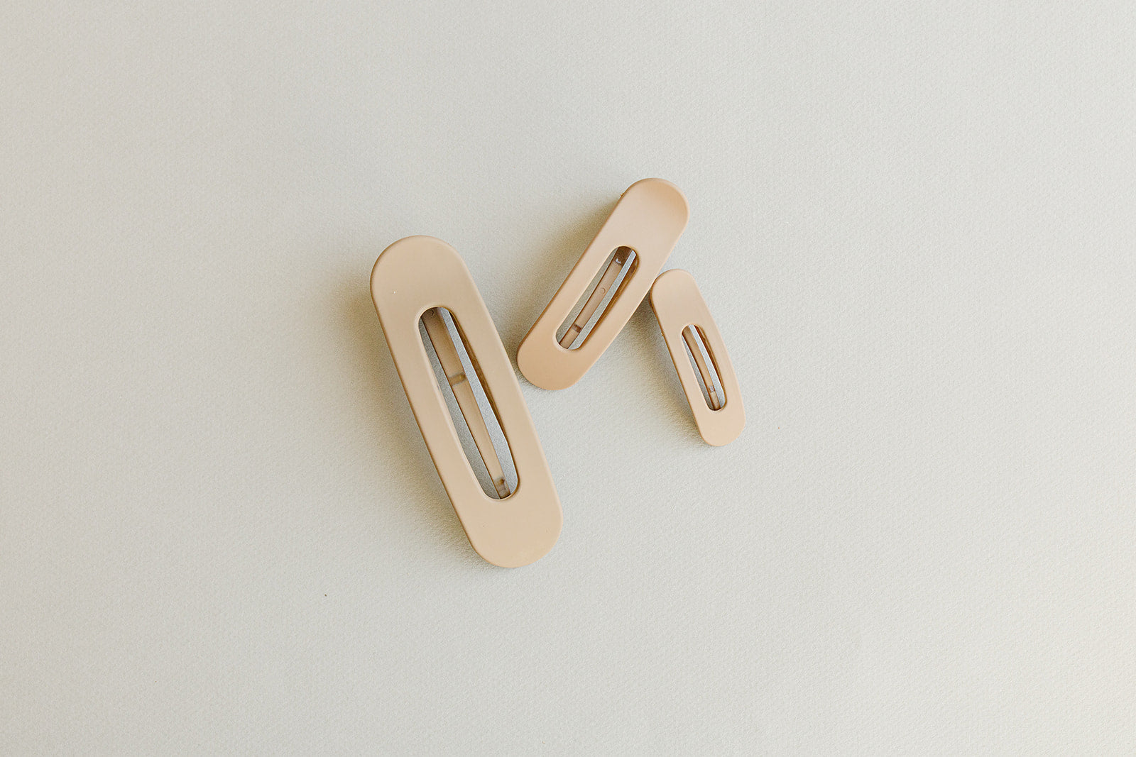 Desert Sol Oval Lay Flat Matte Claw Clip in beige, shown in Mini, Standard and Classic sizes