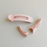 Desert Sol Oval Lay Flat Matte Claw Clip in Light Pink with matching hair accessories on a gray background