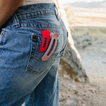 Desert Sol Oval Lay Flat Matte Claw Clips in Hot Pink and Light Pink clipped to a jeans back pocket