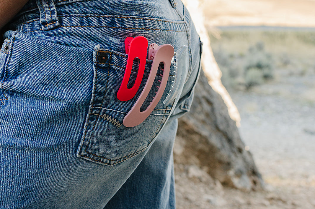 Desert Sol Oval Lay Flat Matte Claw Clips in Hot Pink and Light Pink clipped to a jeans back pocket