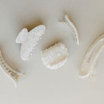 Desert Sol Pearl acrylic hair clip set with an oval lay flat claw clip, classic claw clip, petal claw clip and snap clips in a creamy white marble