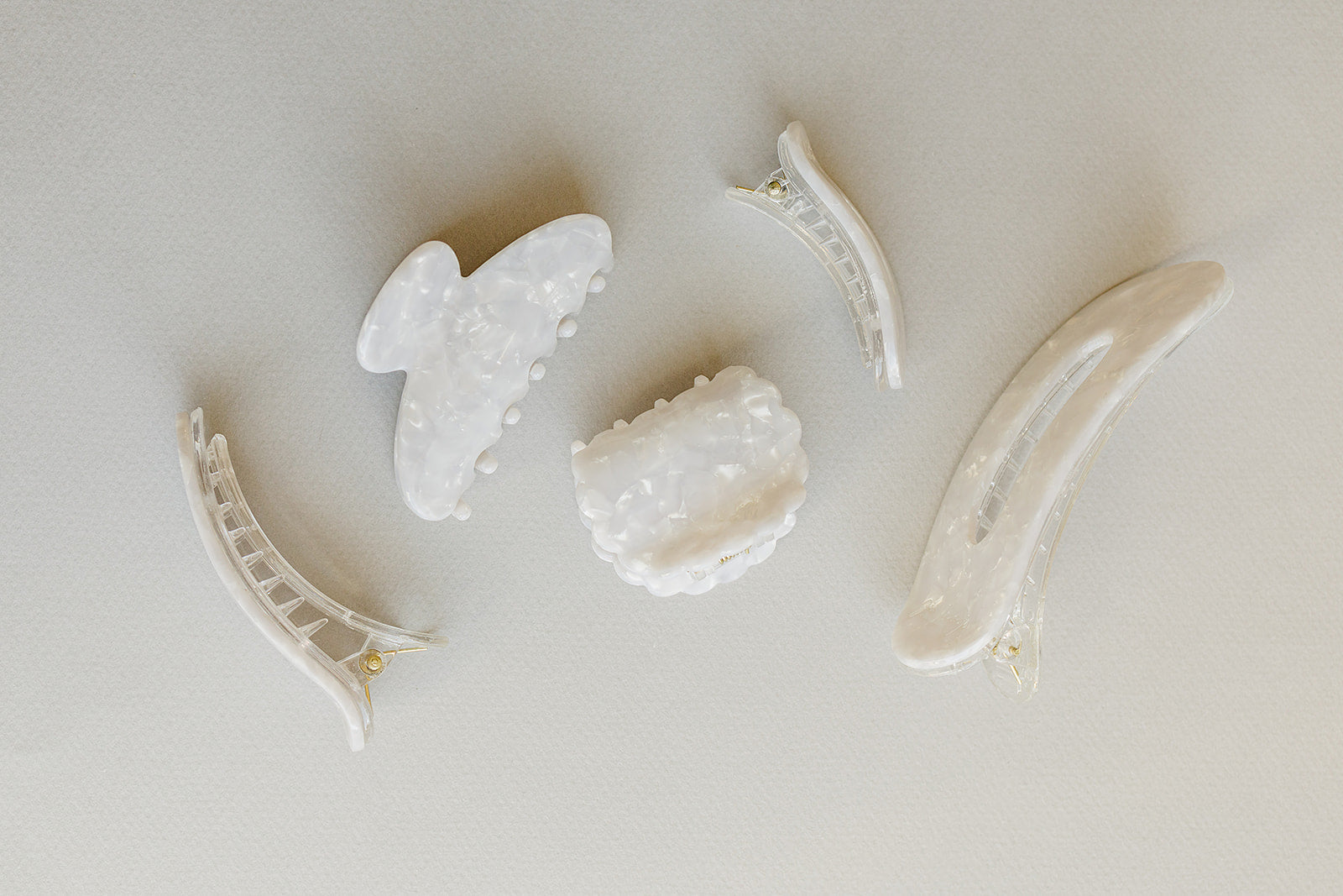 Desert Sol Pearl acrylic hair clip set with an oval lay flat claw clip, classic claw clip, petal claw clip and snap clips in a creamy white marble