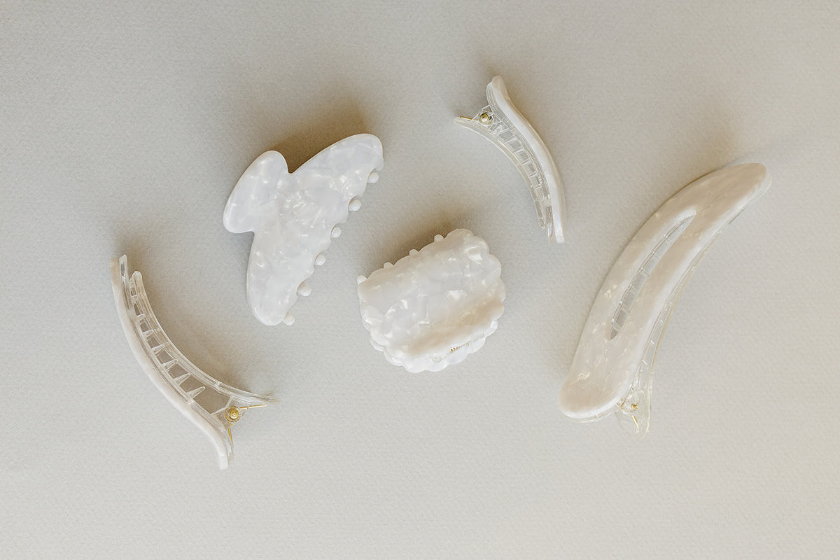 Desert Sol Pearl acrylic hair clip set with an oval lay flat claw clip, classic claw clip, petal claw clip and snap clips in a creamy white marble
