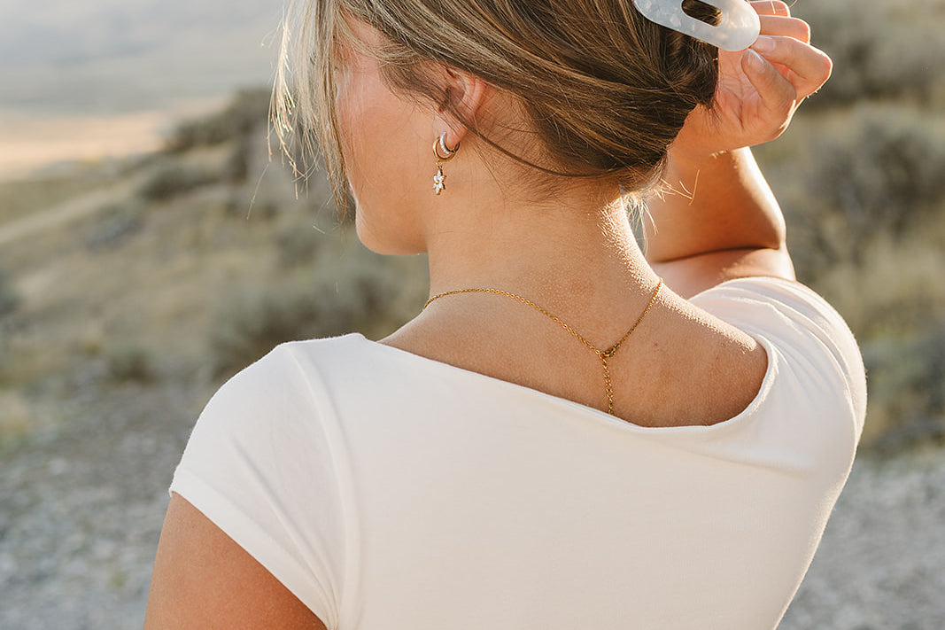 Model with a low bun held by the Desert Sol Oval Lay Flat Acrylic Claw Clip in Pearl