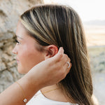 Model wearing the Desert Sol Petal Bracelet with a crystal white flower