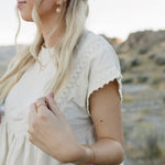 Model wearing the Desert Sol Petal Bracelet with a purple crystal flower