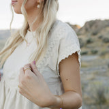 Model wearing the Desert Sol Petal Bracelet with a purple crystal flower