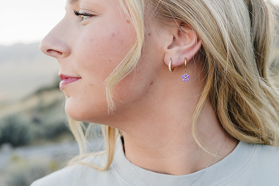Model in profile wearing the Desert Sol Petal Hoop Earrings with a purple crystal flower