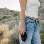 Model holding the Desert Sol Crystal Silk Scrunchie in Plum