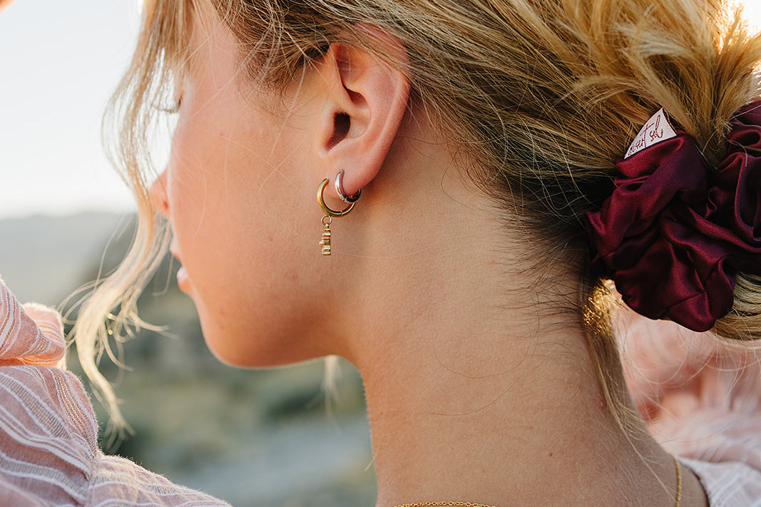 Model with a messy bun tied with the Desert Sol Mulberry Silk Scrunchie in Plum