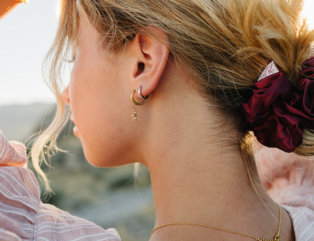Model with a messy bun tied with the Desert Sol Mulberry Silk Scrunchie in Plum