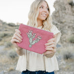 Model holding the Desert Sol Prickly Mauve Pear corduroy medium pouch in pink