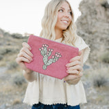 Model holding the Desert Sol Prickly Mauve Pear corduroy medium pouch in pink