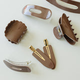 Desert Sol Roman Clay acrylic hair clip set with an oval lay flat claw clip, classic claw clip, petal claw clip and snap clips in warm brown