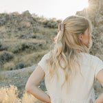 Model with a half up hairstyle held by the Desert Sol Petal Claw Clip in Roman Clay