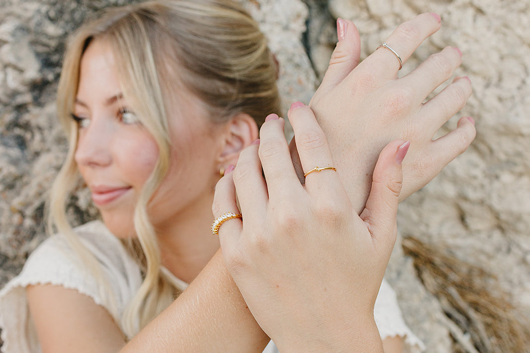 Model wearing the Desert Sol Solara pearl bracelet in gold with stacked gold rings