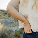 Desert Sol Solara pearl bracelet in gold on a hand tucked into a jeans pocket