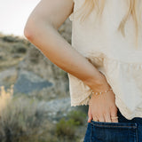 Desert Sol Solara pearl bracelet in gold on a hand tucked into a jeans pocket