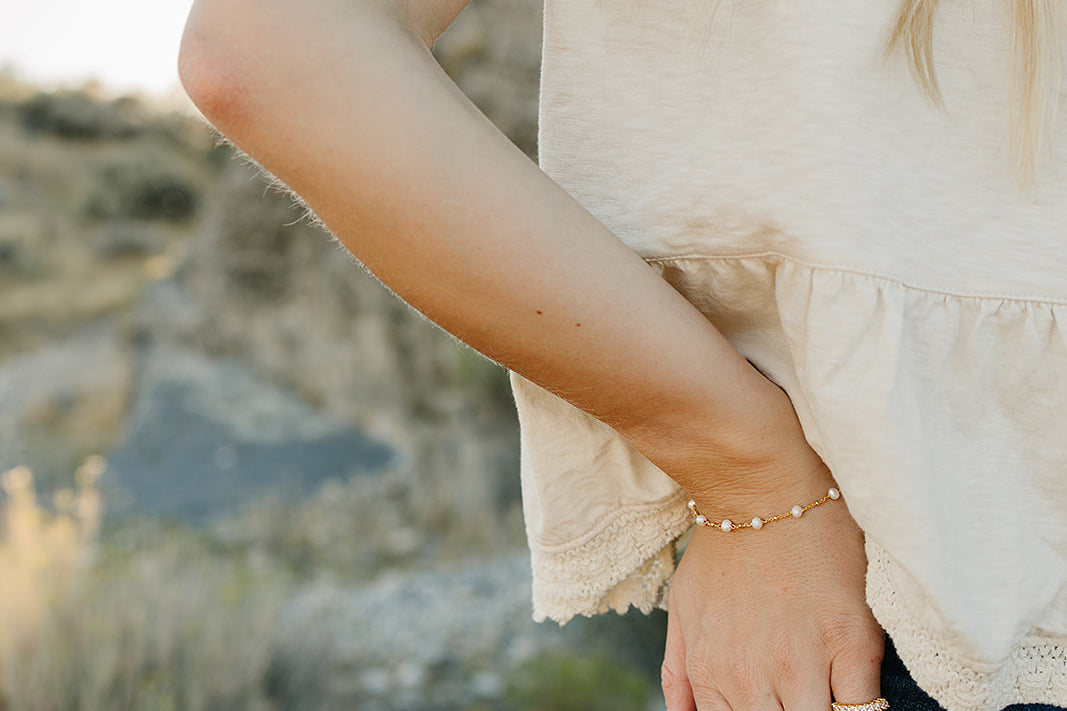 Desert Sol Solara pearl bracelet in gold on a hand tucked into a jeans pocket
