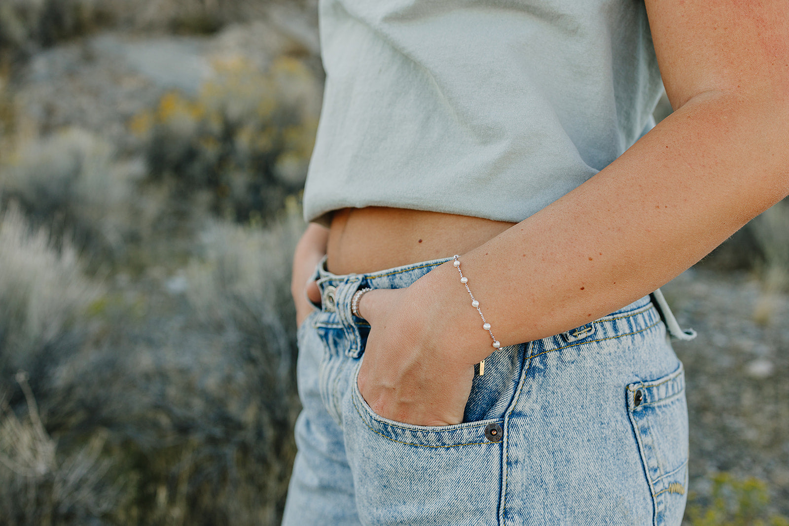 Desert Sol Solara pearl bracelet in silver on a hand in a jeans pocket