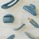 Desert Sol Storm Blue acrylic hair clip set with an oval lay flat claw clip, classic claw clip, petal claw clip and snap clips on white marble