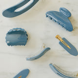 Desert Sol Storm Blue acrylic hair clip set with an oval lay flat claw clip, classic claw clip, petal claw clip and snap clips on white marble