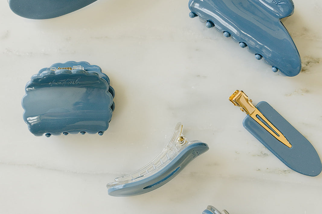 Desert Sol Storm Blue acrylic hair clip set with an oval lay flat claw clip, classic claw clip, petal claw clip and snap clips on white marble