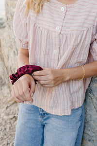 Model wearing the Desert Sol Sundown Chain Bracelet in gold with a plum Mulberry Silk Scrunchie on her wrist