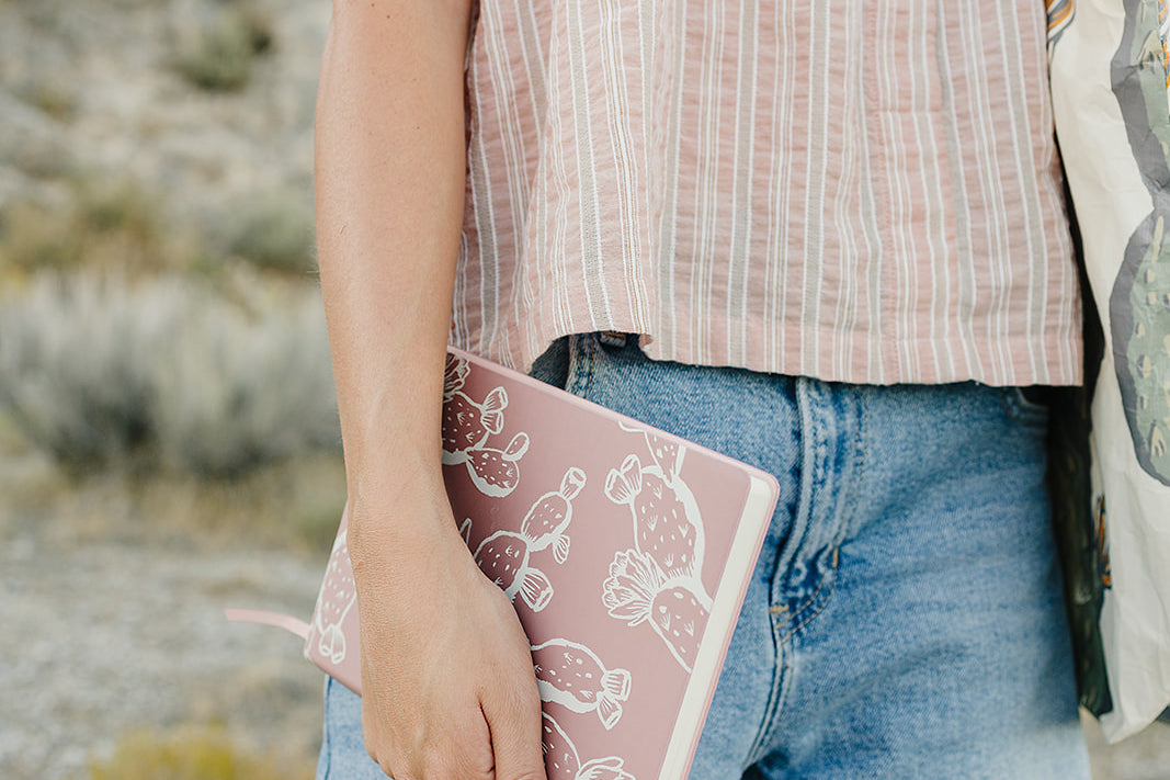 Model holding the Desert Sol Wild Bloom vegan leather journal in pink