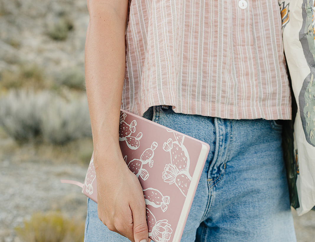 Model holding the Desert Sol Wild Bloom vegan leather journal in pink