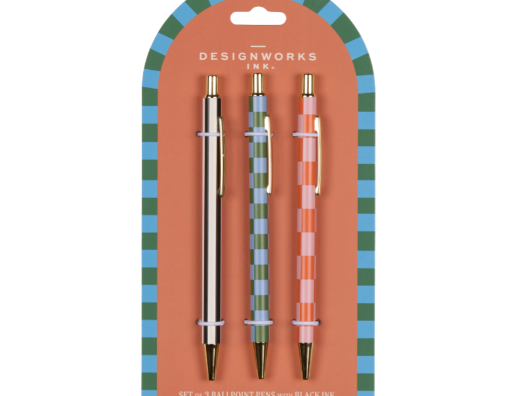 A Dopo Pen Set of 3, three patterned ballpoint pens, one gold, one green striped and one pink patterned, on a blue and green checkered backer card