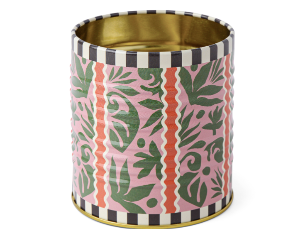 A Dopo Tin Jungle, a pink tin pencil cup with green leaves and terracotta stripes, a black and white checkered rim and a gold interior