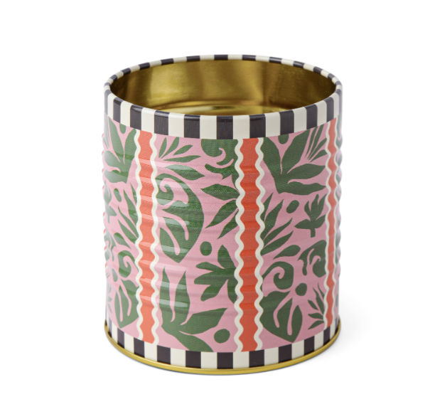 A Dopo Tin Jungle, a pink tin pencil cup with green leaves and terracotta stripes, a black and white checkered rim and a gold interior