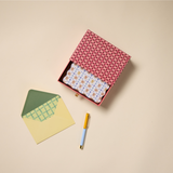 Designworks Notecards Set of 16, open red patterned box with a green check card, green and yellow envelopes and pens