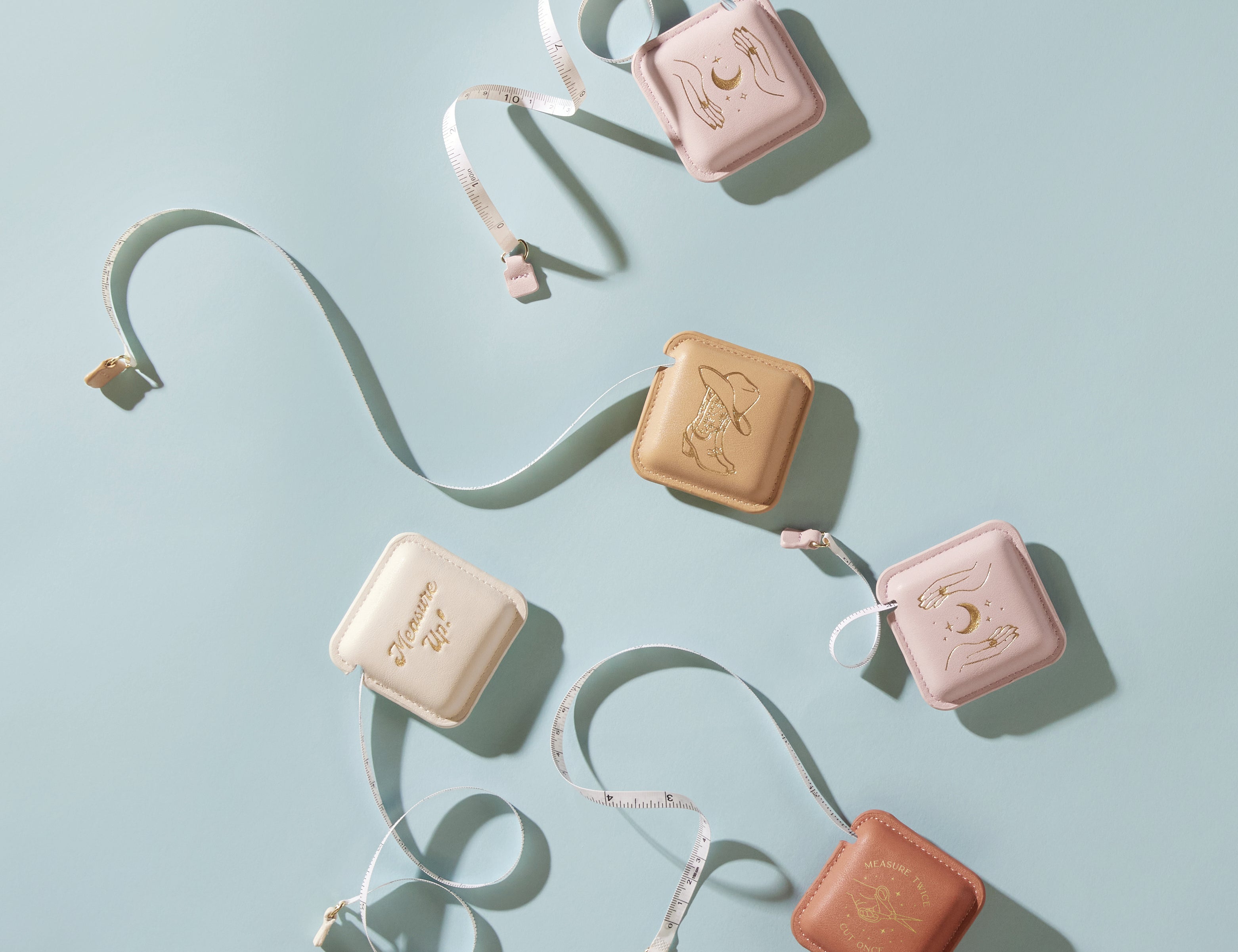 Pocket Tape Measure, a pocket tape measure in a stitched vegan leather case with debossed gold foil art